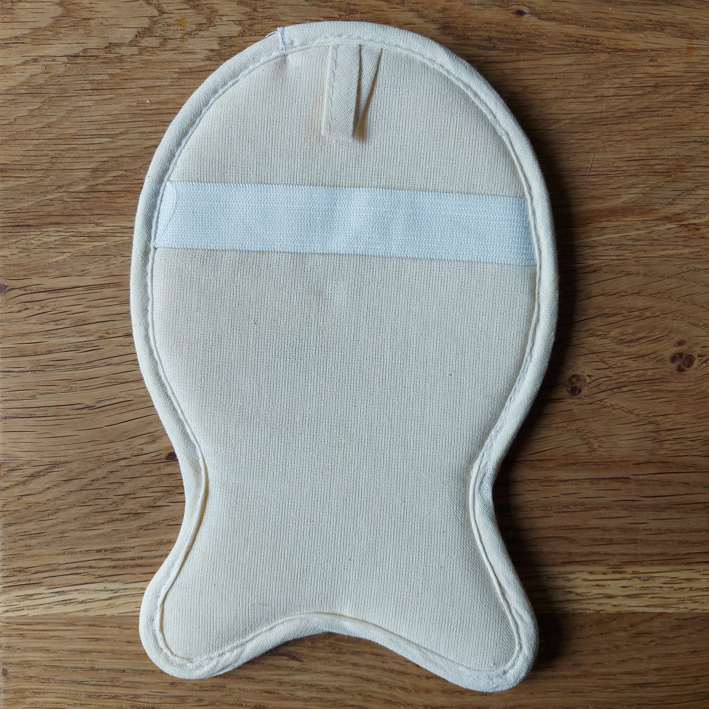 Loofah naturel, salle de bain zéro déchet, soin naturel,Une éponge naturelle en luffa transformée en gant de massage en forme de poisson est posée sur une table en bois. Disponible chez ILELI savons Orsay