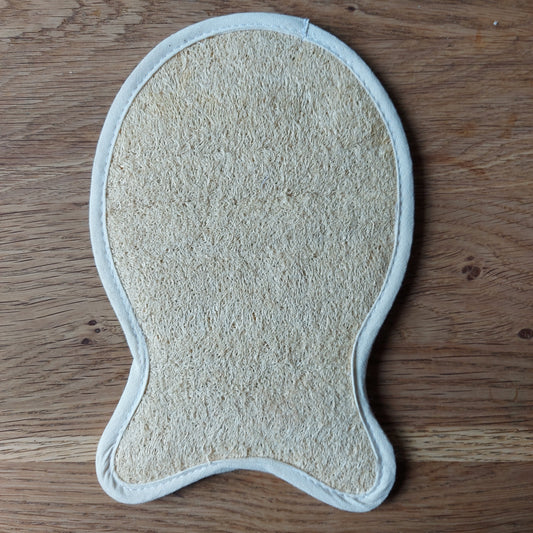 Une éponge naturelle en luffa transformée en gant de massage en forme de poisson est posée sur une table en bois. Disponible chez ILELI savons Orsay, Eponge Loofah naturel "Poisson", Massage naturel, produit de bain biodégradable, salle de bain zéro déchet